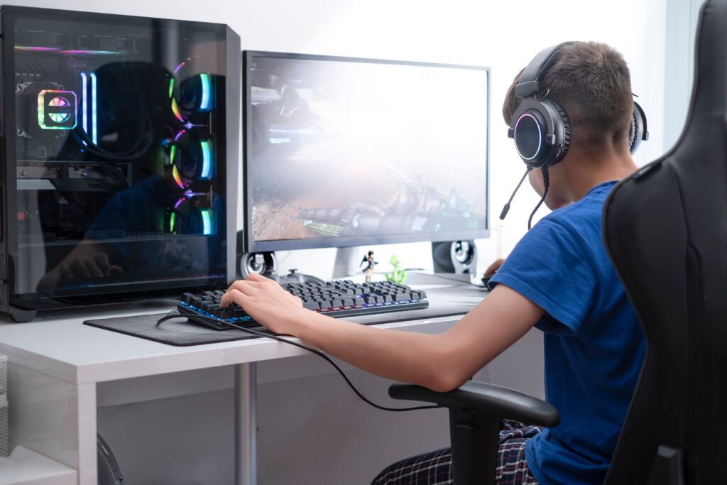 a teenager plays video games on a computer gaming, video game addiction in adolescence, selective focus